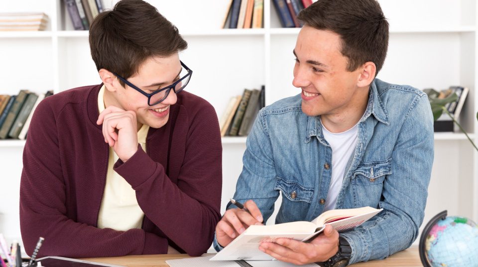 smiling students reading book v2 MUET Preparation Course